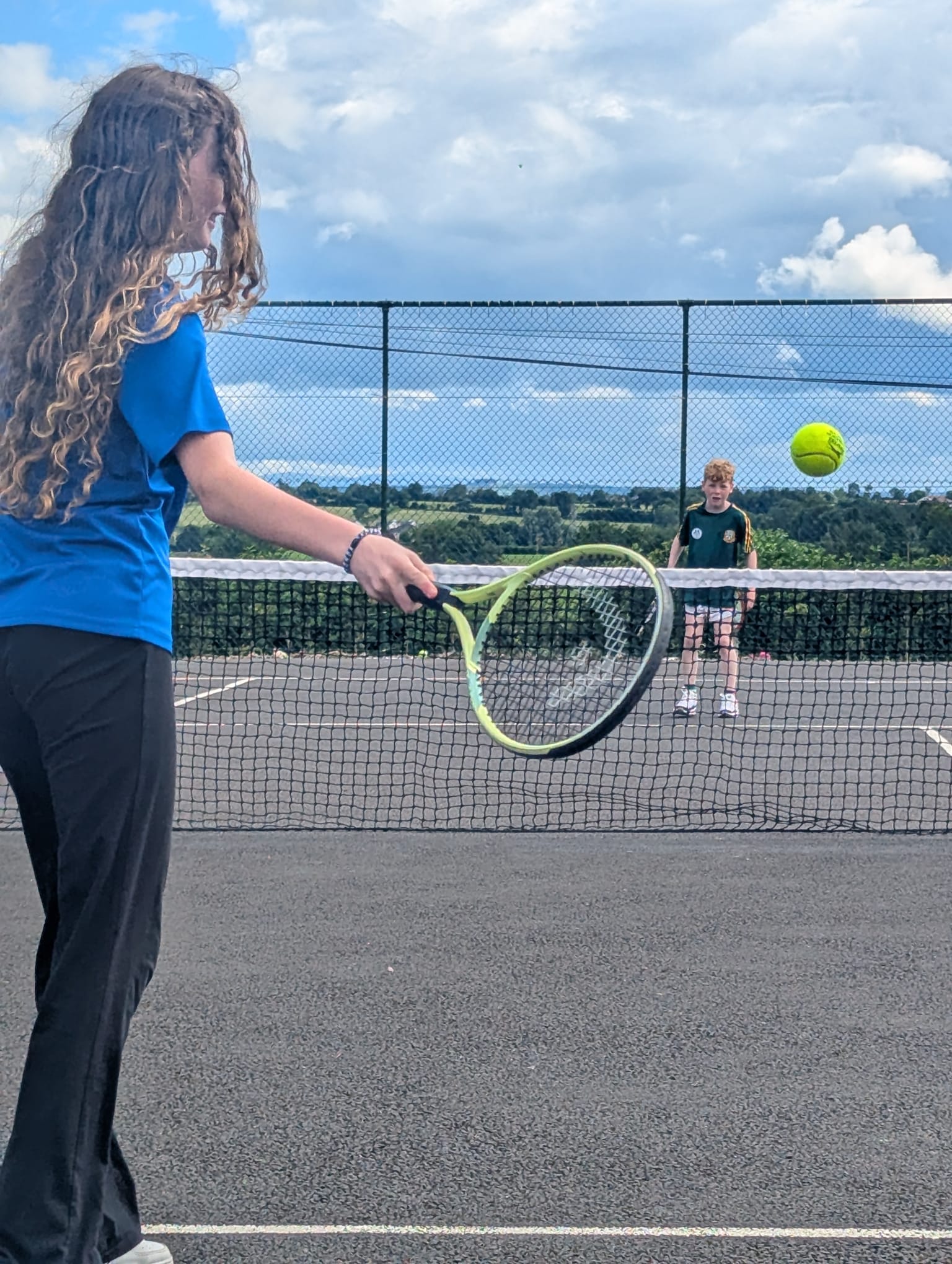 A junior volleying at the net
