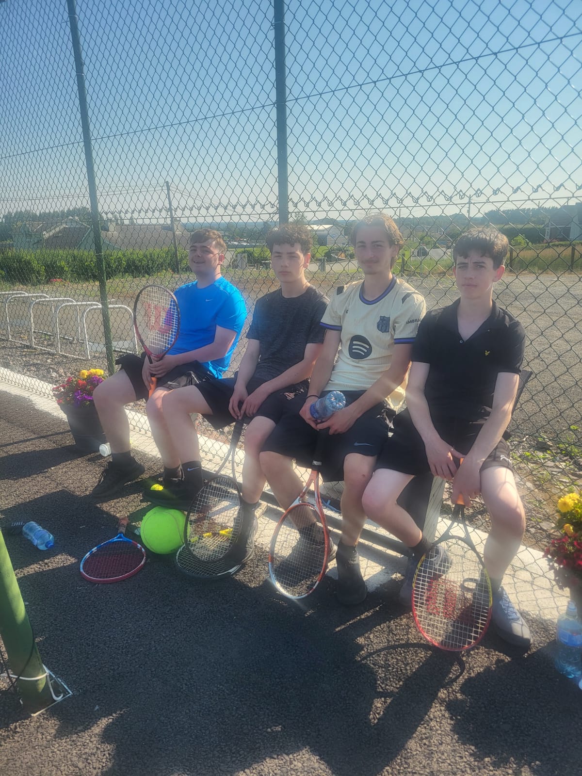 Teenage members resting on the bench between games