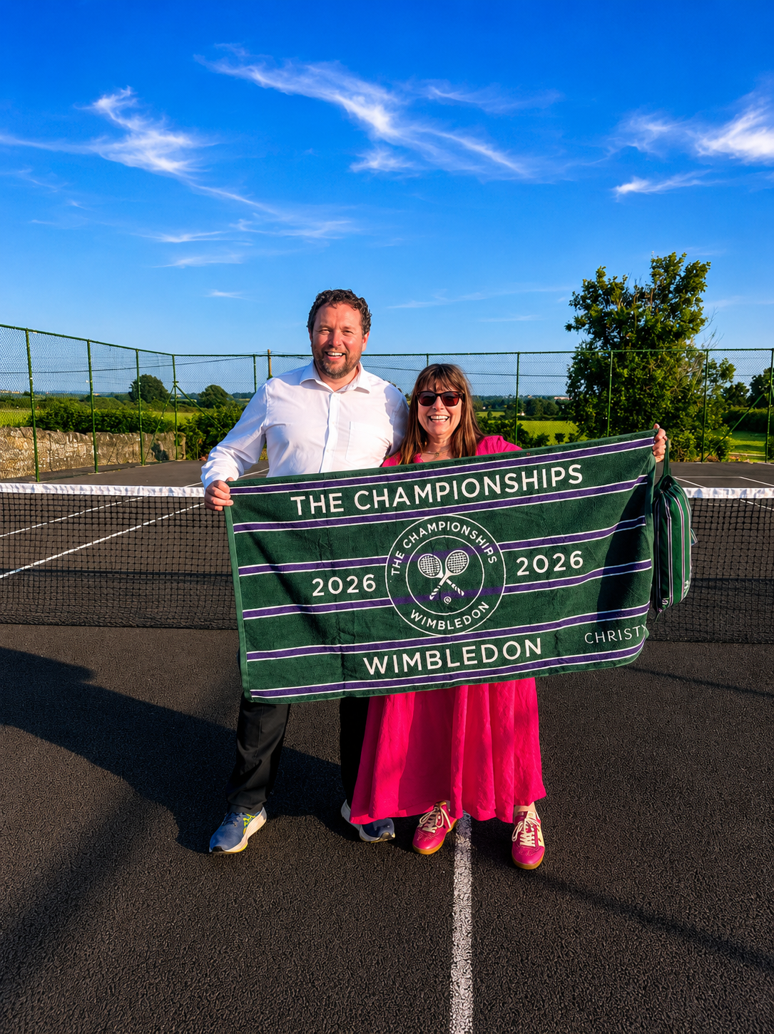 Two members holding a Wimbledon 2026 banner